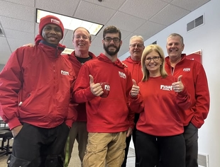 Members of the local FISH Window Cleaning team together in red uniforms