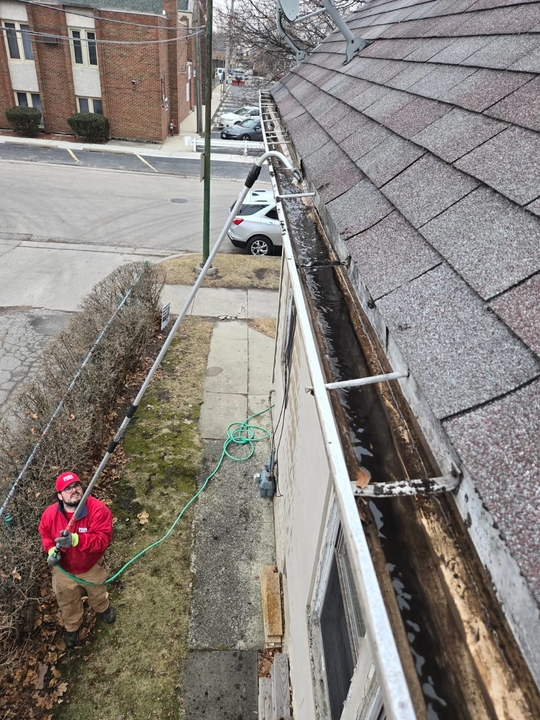 Local FISH technician clearing gutters on a Chicago-area home